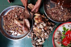 The more, the merrier: A committee member of the Darussalam Mosque in Surakarta, Central Java, slices beef into small pieces to use as one of the ingredients of Samin porridge. JP/ Ganug Nugroho Adi