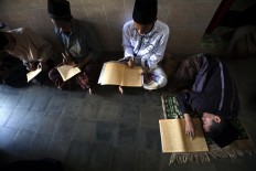 A student sleeps while others recite the Quran. Lessons start after subuh (dawn) prayers until dhuhur (midday) prayers. JP/Sigit Pamungkas
