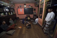Students wait to break the fast by singing, accompanied by a tambourine. JP/Sigit Pamungkas