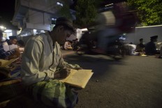 Hundreds of santri in Lirboyo Islamic boarding school, East Java, recite the Quran after tarawih (evening prayers) on the street. During Ramadhan, the number of students increases drastically. JP/Sigit Pamungkas