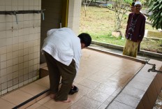 Yadi (student wearing white cap) reminds a friend to take off his sandals at An Nur Mosque. JP/Aman Rochman
