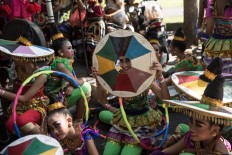 A young woman poses for a photo before performing at the opening of the 39th Bali Art Festival at the Bajra Sandhi Monument in Denpasar. JP/Agung Parameswara