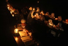 Students of Baitul Mustofa Islamic boarding school recite the Quran outdoors by lamp light. JP/Maksum Nur Fauzan