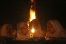 Two female students of Baitul Mustofa Islamic boarding school talk before the recital begins. JP/Maksum Nur Fauzan