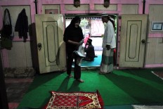 Shinta arranges a sajjada (prayer mat) while waiting to break the fast. JP/Magnus Hendratmo