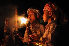 A boy blows out a torch at the close of a takbir torch parade at Makmur Mosque in Basin, Kebonarum, Klaten, Central Java, on Saturday, June 24, 2017. JP/ Magnus Hendratmo