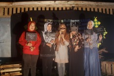 Five women are photographed in a booth built by mosque youths in Payaman Secang, Magelang, Central Java, on Saturday night, June 24, 2017. The eve’s festivities included fireworks and a torch parade. JP/Syamsul Huda M.Suhari