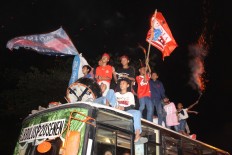 Muslim teenagers recite the name of Allah while riding atop a bus in a convoy around Jakarta for takbiran on Saturday, June 24, 2017. JP/Ibrahim Irsyad