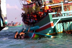 Sea offering: Locals use a number of boats to join the Lomban procession off Kartini Beach in Jepara, Central Java. Held a week after Idul Fitri, residents joining the procession floated various offerings such as a buffalo head, agricultural produce and ketupat (rice cakes boiled in plaited coconut leaves) to show their gratitude. JP/ Ganug Nugroho Adi