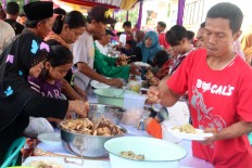 Digging in: Residents enjoy ketupat in Kaliwungu district in Kendal, Central Java, during the Syawalan celebration. JP/ Suherdjoko