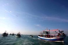 Rows of boats carrying fishermen and visitors are heading to the site where the Lomban Festival takes place in Jepara Bay, Central Java, on July 2. The procession is held by locals to thank God for his blessings and to preserve local culture. JP/Maksum Nur Fauzan