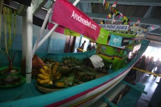 A buffalo head, agricultural produce and ketupat (steamed rice packed in diamond-shaped woven palm leaves) are put on a boat to be floated as offerings to show fishermen’s gratitude. JP/Maksum Nur Fauzan