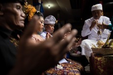 Novi and Kadek sit in front of a priest during a Balinese traditional wedding on Feb. 2. JP/Anggara Mahendra