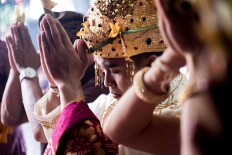 Kadek and Novi perform Hindu prayers during the ceremony at Banjar Taman Yangbatu, Denpasar, on Feb. 2. JP/Anggara Mahendra