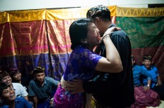 Novie, the bride, laughs when the Banjar Taman Yangbatu youth group urges her to kiss her husband, Kadek, as a symbol of living in harmony in their married life. JP/Anggara Mahendra