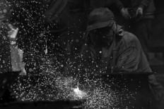 A worker uses a welding tool to cut the metal of a ship. JP/Sigit Pamungkas