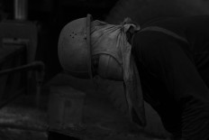 A worker observes his surroundings before cutting iron with a welding tool so as not to endanger his colleagues. JP/Sigit Pamungkas