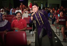 A singer sings an Indian song during the festival while spectators take pictures. JP/Aman Rochman