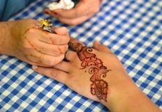 A visitor has her hand painted on the sidelines of the festival. JP/Aman Rochman