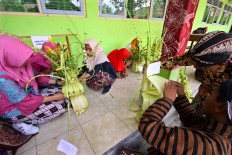 Students create wedding ornaments made of janur (young coconut leaves). JP/Aditya Sagita