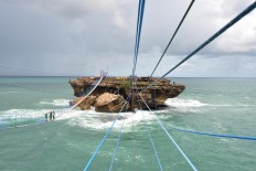 Some tourists prefer to cross the strait to Timang islet by using a hanging bridge. The bridge is made of 500 wooden planks lined up along 100 meters. JP/Magnus Hendratmo