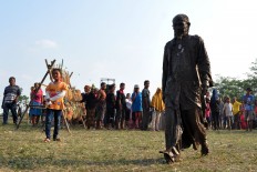  A local artist, Agus Bimo, after performing as a mud man to express himself while wallowing in the mud. JP/Magnus Hendratmo