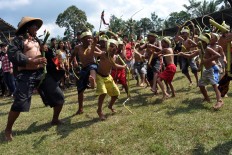 Children and a man perform the Kuda Lumping dance. The kuda (horse) is made of banana stalks. JP/ Magnus Hendratmo