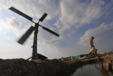 A farmer walks across the field to check the water level in Santing village. Antara/Dedhez Anggara