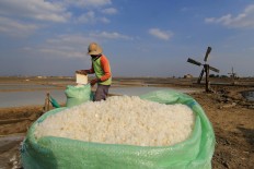 A farmer fills up a sack of salt. Antara/Dedhez Anggara