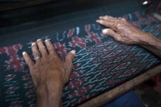 Quality control: each Parengan fabrics needs to undergo tight quality control. Crafts-men use their bare hands to feel and sense the details and quality of the fabric. JP/ Sigit Pamungkas