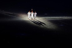 Torch bearers run their last lap during the SEA Games opening ceremony at the Bukit Jalil Stadium in Kuala Lumpur. JP/Seto Wardhana