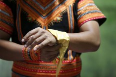Alimudin ties a yellow handkerchief on his left wrist before performing in the mass dance. JP/Hotli Simanjuntak