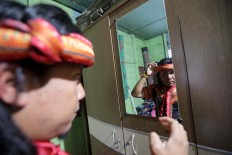 Alimudin checks his appearance before the mass dance. JP/Hotli Simanjuntak