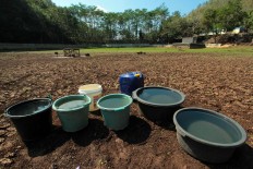 Villagers put the water, which they get from other locations, in buckets and jerrycans to separate the mud and the clean water. JP/Aditya Sagita