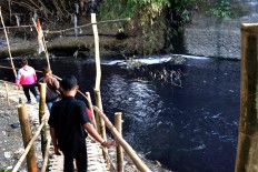 Three men walk along the riverbanks of the brackish Jenes River, which has been polluted by chemical waste from nearby batik factories. Batik is the main source of livelihood for Surakarta’s Laweyan village, renowned for its sogan batik. JP/Stefanus Ajie