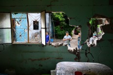 Local residents stand outside their home, severely damaged by Thursday night's 8.2-magnitude quake, in Juchitan, Oaxaca, Mexico, on September 10, 2017.Rescuers pulled bodies from the rubble 
and grieving families carried coffins through the streets Saturday after Mexico's biggest earthquake in a century killed 65 people. AFP/ Ronaldo Schemidt