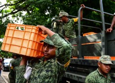 Mexican soldiers unload water in Juchitan 
de Zaragoza, state of Oaxaca on September 10, 2017, for those affected by the 8.2 magnitude earthquake that hit Mexico's Pacific Coast on September 8. 
Mexican families picked nervously at the 
ruins of their homes Sunday as help trickled in after a huge earthquake killed 90 people. People in Juchitan were afraid to return to their homes, fearing the effects of hundreds of aftershocks -- 
but camped within sight of them to prevent looting.  AFP/ Ronaldo Schemidt