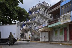 A soldier stands guard a few metres away from the Sensacion hotel which collapsed with the powerful earthquake that struck Mexico overnight, in Matias Romero, Oaxaca State, on September 8, 2017. Mexico's most powerful earthquake in a 
century killed at least 35 people, officials said Friday, after it struck the Pacific coast, wrecking homes and sending families fleeing into the streets. AFP/ Ronaldo Schemidt
