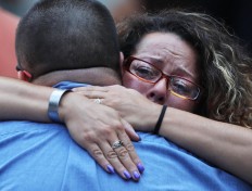 A woman hugs a man during a commemoration ceremony for the victims of the September 11 terrorist attacks at the National September 11 Memorial and Museum fifteen years after the day on September 11, 2016 in New York City. Throughout the country services are being held to remember the 2,977 people who were killed in New York, the Pentagon and in a field in rural Pennsylvania.   AFP/Getty Images/Spencer Platt