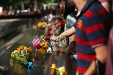 People gather at one of the pools at the National September 11 Memorial following a morning commemoration ceremony for the victims of the terrorist attacks fifteen years after the day on September 11, 2016 in New York City. Throughout the country services are being held to remember the 2,977 people who were killed in New York, the Pentagon and in a field in rural Pennsylvania.   AFP/Getty Images/Spencer Platt