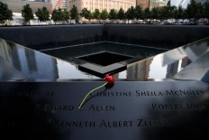 A flower is left at the North pool during a commemoration ceremony for the victims of the September 11 terrorist attacks at the National September 11 Memorial, September 11, 2017 in New York City. In New York City and throughout the United States, the country is marking the 16th anniversary of the September 11 terrorist attacks.  AFP/Getty Images/Drew Angerer