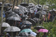 Rohingya Muslim refugees protect themselves from rain in Balukhali refugee camp near the Bangladesh town of Gumdhum on September 17, 2017.
Heavy monsoon rain heaped new misery September 17 on hundreds of thousands of Muslim Rohinyga stuck in makeshift camps in Bangladesh after fleeing violence in Myanmar, as authorities started a drive to force them to a new site. The United Nations says 409,000 Rohingyas have now overwhelmed Cox's Bazar since August 25 when the military in Buddhist-majority Myanmar launched operations in Rakhine state. AFP/ Dominique Faget 