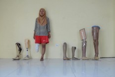 Paralympic athlete Ratifah poses in a line-up showing the variety of prosthetic limbs worn by athletes of the Indonesian delegation. JP/Maksum Nur Fauzan