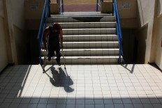 A paralympic athlete descends the stairs of the NPC training center after training exercises. JP/Maksum Nur Fauzan