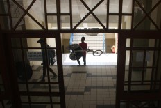 A trainer carries a racing wheelchair after training exercises. JP/Maksum Nur Fauzan