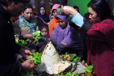 Female villagers cook tumpeng (rice cones) with side dishes of vegetables for the offering. JP/Magnus Hendratmo