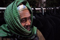 An elderly villager tries to keep warm. JP/Magnus Hendratmo
