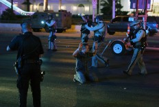 Police officers stop a man who drove down Tropicana Ave. near Las Vegas Boulevard and Tropicana Ave, which had been closed after a mass shooting at a country music festival that left at least 2 people dead nearby on October 2, 2017 in Las Vegas, Nevada. The man was released.  AFP/Getty Images/ Ethan Miller