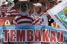 Women workers grouped in the Indonesian Tobacco Farmers Association don the national colors to protest foreign intervention in the domestic tobacco industry in Pamekasan, Madura Island. JP/Wahyoe Boediwardhana