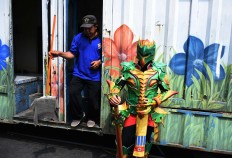 A participant in cosplay stands in front of a toilet. JP/Aman Rochman
